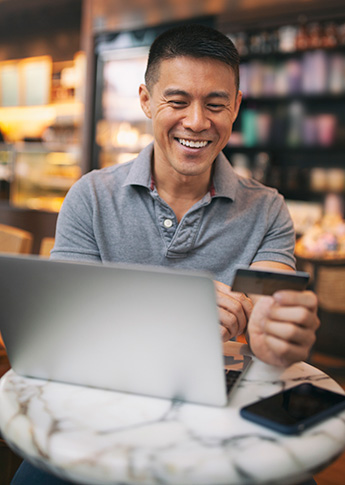 Man using credit card in coffee shop